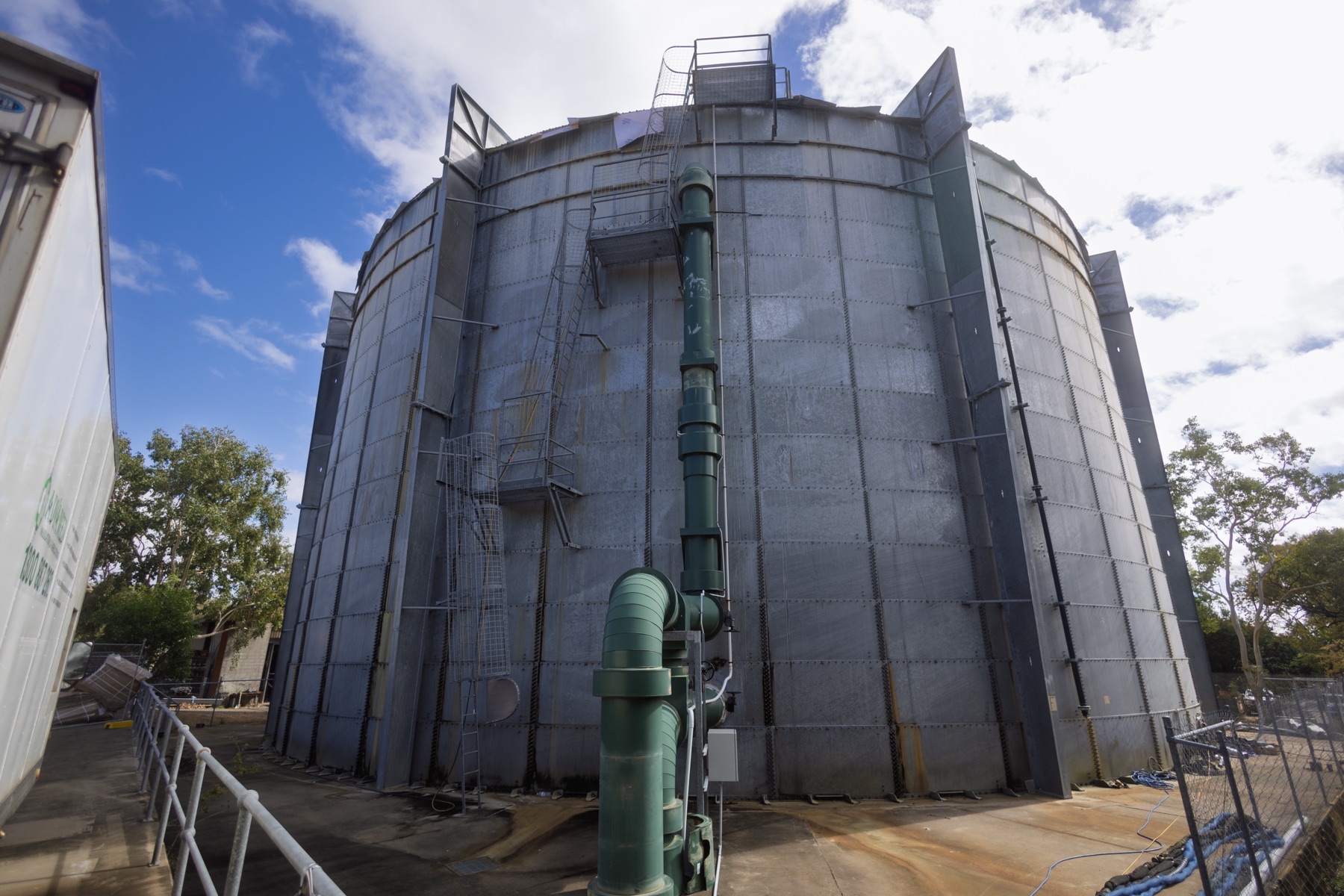 ATM Tanks — The completed steel tank photographed from ground level against a blue sky, showing its full height and access stairs